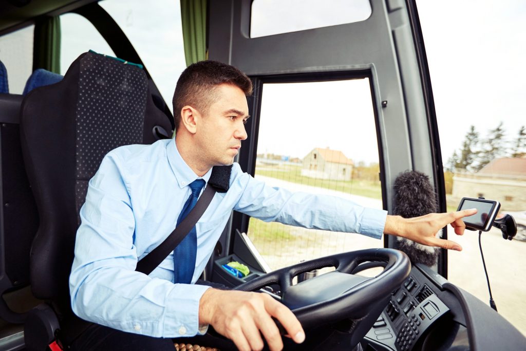 transport, transportation, navigation and people concept - bus driver entering address to gps navigator